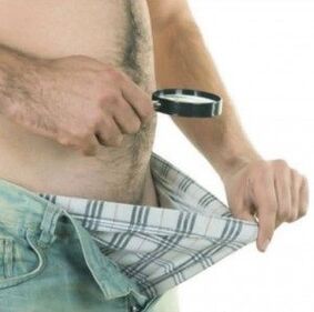 Ein Mann blickt in seine Hose und möchte seinen Penis mit Gel vergrößern